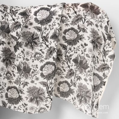 Gjennomsiktig linstoff med svarte blomster.