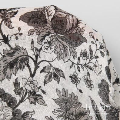 Linstoff med svarte blomster.