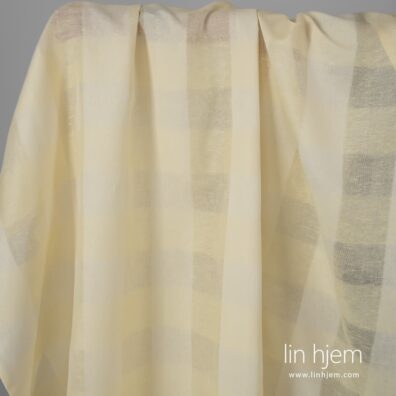 Gulaktig halvlin stoff i gjennomsiktige striper.