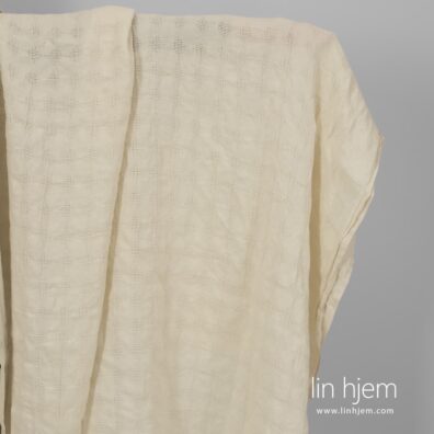 Vasket gulaktig linstoff med romber.