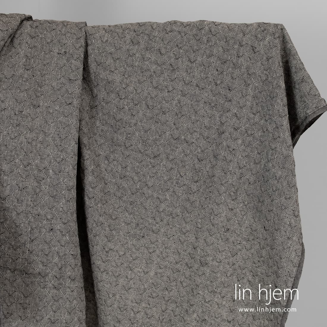 Vasket svart linstoff med romber.