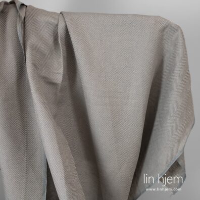 Grått halvlin stoff i gran mønster.