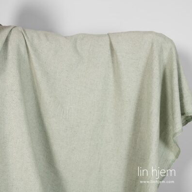 Mønstret grønnaktig halvlin stoff.