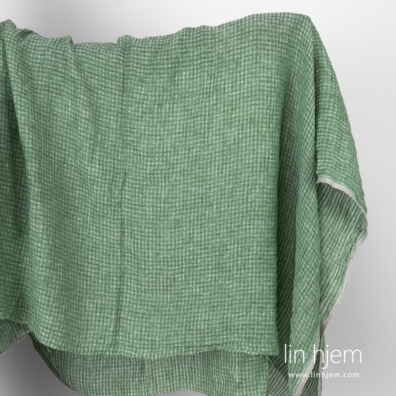 Vasket grønt linstoff i gjennomsiktige ruter.