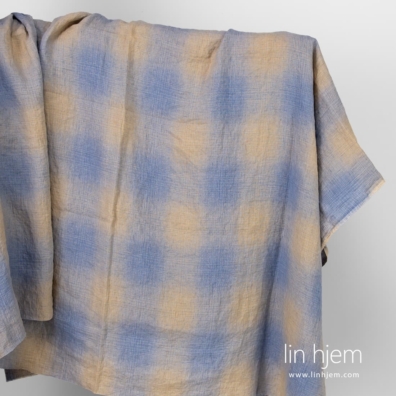 Vasket linstoff i lyseblå og brunaktige ruter.