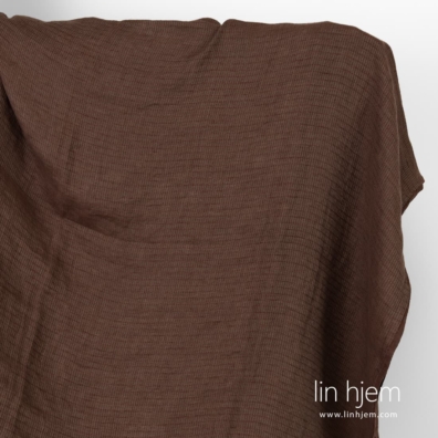 Vasket brunt linstoff i mønstrete striper.