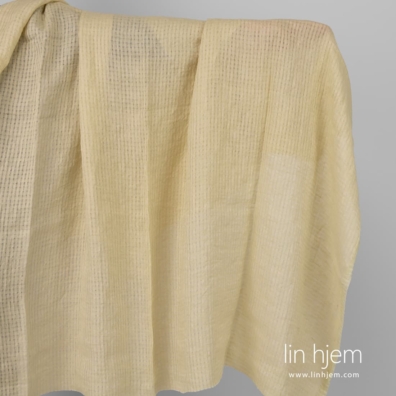 Vasket gulaktig linstoff i gjennomsiktige ruter.