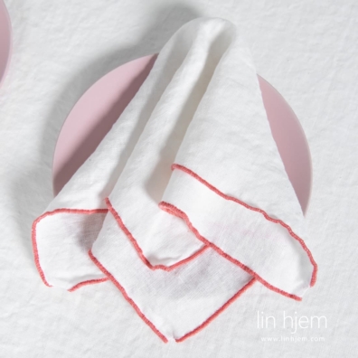 ARVO hvit linserviett med rødaktig kant.