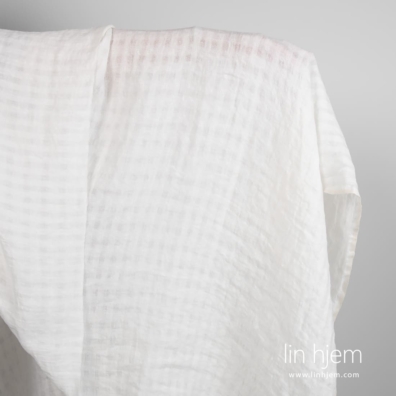 Hvitt linstoff i gjennomsiktige ruter, vasket