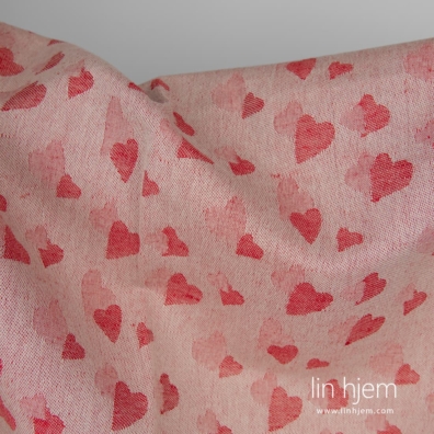 Rødt halvlinstoff med små hjerter passer til å sy klær og hjemmetekstiler