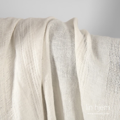 Melkehvit linstoff med tette og sjeldne striper og romber