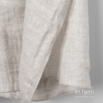 Vasket linstoff i fiskebein mønster vevd av hvitt og naturlig grått (ufarget) garn