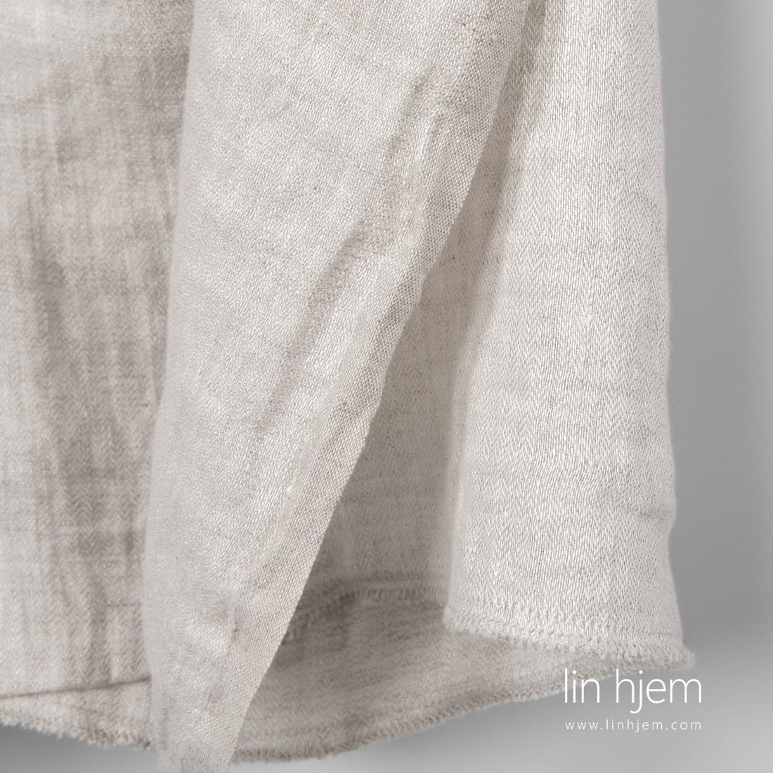 Vasket linstoff i fiskebein mønster vevd av hvitt og naturlig grått (ufarget) garn