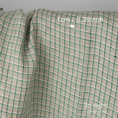 Linstoff med ruter vevd av naturlig grått (ufarget), melkehvitt, svart og grønt garn