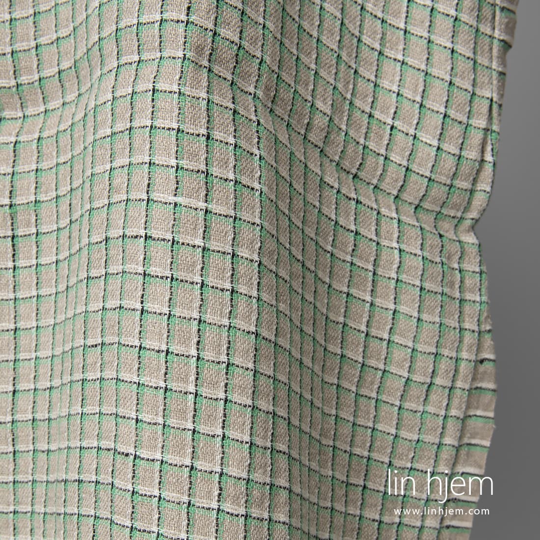 Grått linstoff med grønne ruter vasket passer til å sy klær og hjemmetekstiler