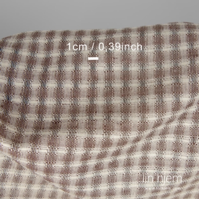 Halvlin stoff med gjennomsiktige ruter vevd av lys gult (krem) og mørkebrunt garn