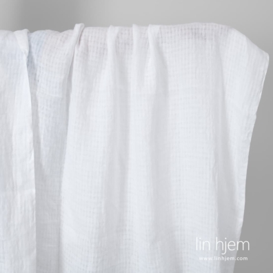 Knallhvitt linstoff i gjennomsiktige ruter vasket