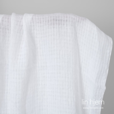 Knallhvitt linstoff i gjennomsiktige ruter vasket egner seg til å sy klær og hjemmetekstiler