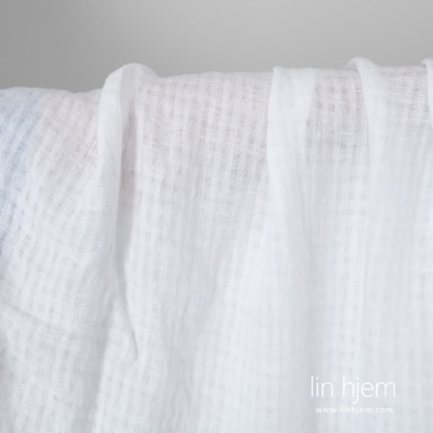 Knallhvitt linstoff i gjennomsiktige ruter vasket, mykt, skånsomt