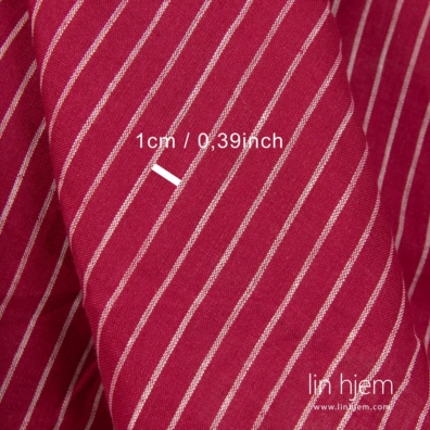 Stripete linstoff vevd av rødt og knallhvitt garn