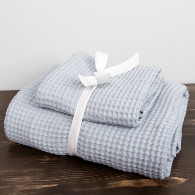 Sett med isfarget håndklær er bundet med et bredt bånd