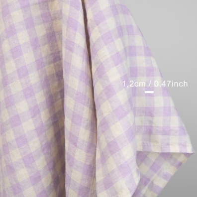 Linstoff med ruter vevd av lys lilla og vaniljefarget (gulaktig hvit) garn, vasket