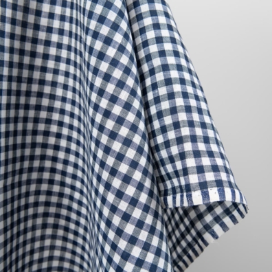 Linstoff med hvite og mørkeblå ruter for å sy klær og hjemmetekstiler