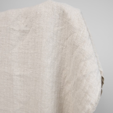 Kraftig linstoff i "fiskebensmønster" vevd av naturlig farge (ufarget, brungrå) og hvitt garn, vasket