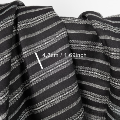 Linstoff med svarte og hvite mønstrete striper for å sy klær og hjemmetekstiler