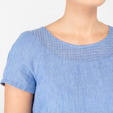 Blå linkjole med detalj av et tynnere stoff rundt den runde halsen