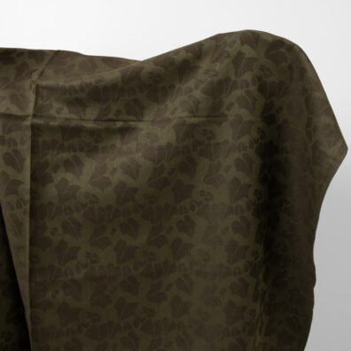 Grønt halvlin stoff med bladmotiv