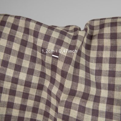 Rutete linstoff vevd av lilla og naturfarget (ufarget, brungrått) garn