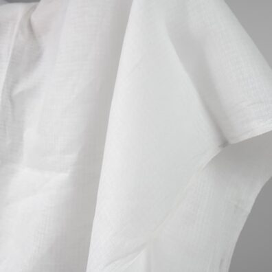 Melkehvitt mønstret linstoff med strukturelle ruter