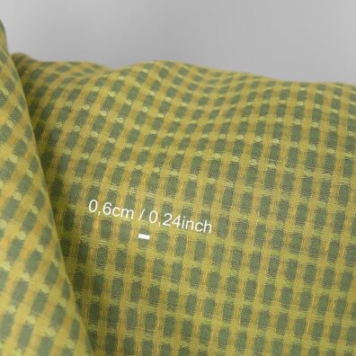 Linstoff med gulgrønt med strukturvev