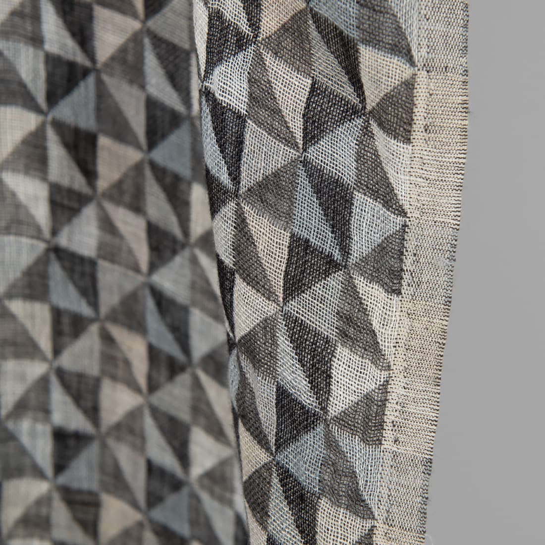 Linstoff med svart-grå trekanter vasket for sying klær, hjemmetekstiler