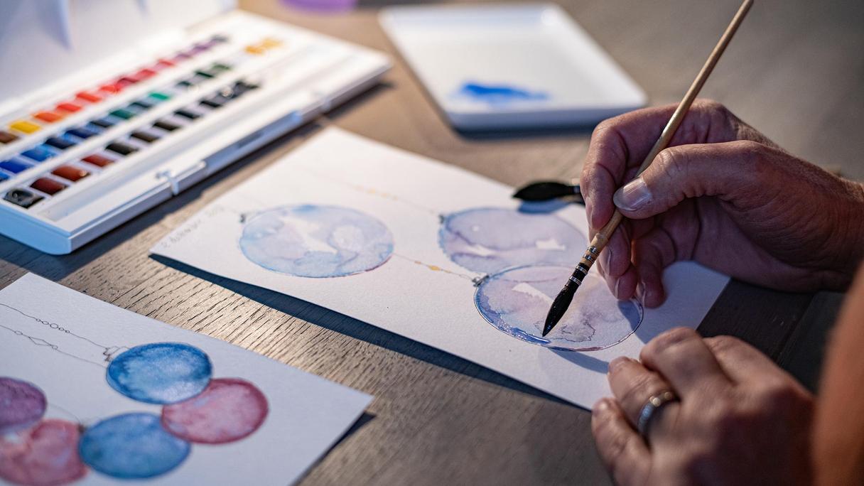 En person målar vid ett bord.