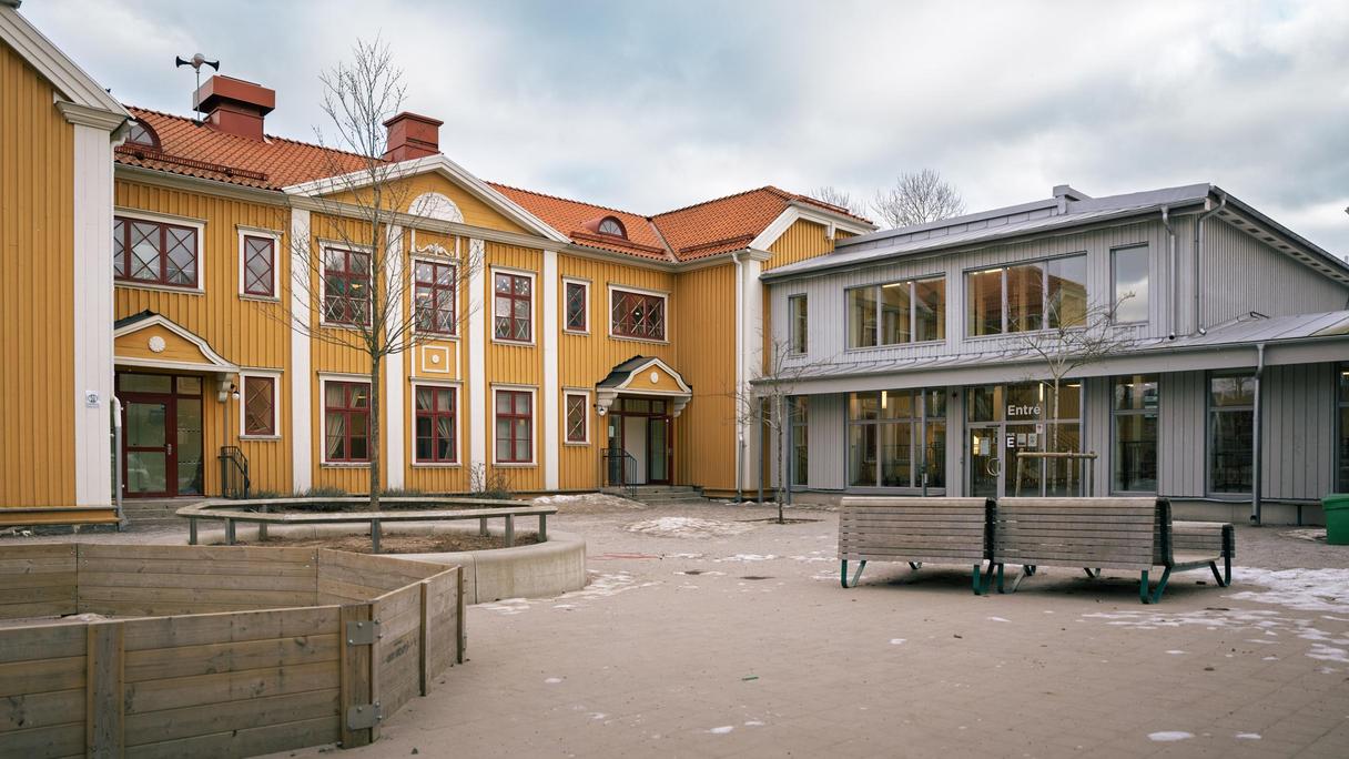 Backaskolans entré med några bänkar i bakgrunden.