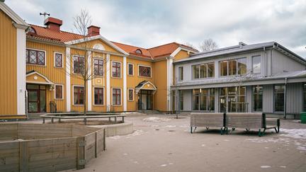 Backaskolans entré med några bänkar i bakgrunden.