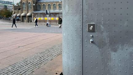 Toalettbyggnad med dricksvattenstation på kortsidan.
