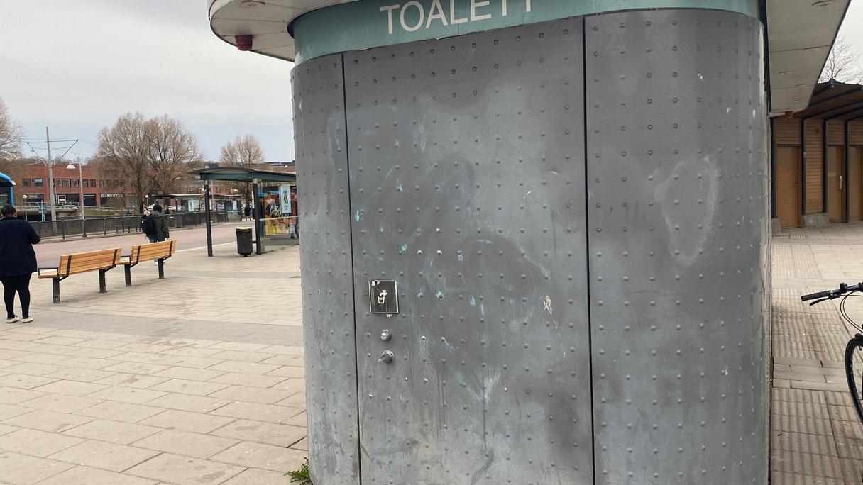 Toalettbyggnad med dricksvattenstation på kortsidan.
