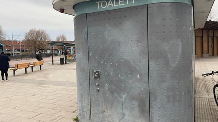 Toalettbyggnad med dricksvattenstation på kortsidan.