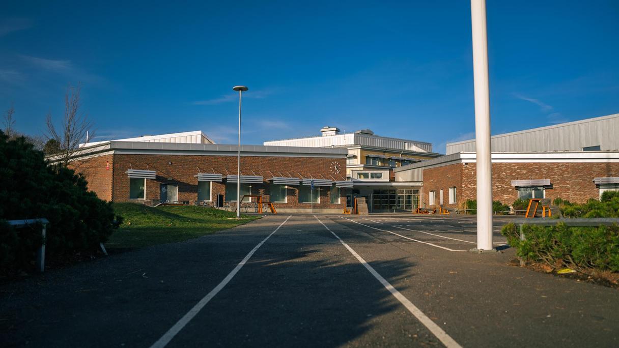 En gångbana som leder fram till en skolbyggnad i tegel.