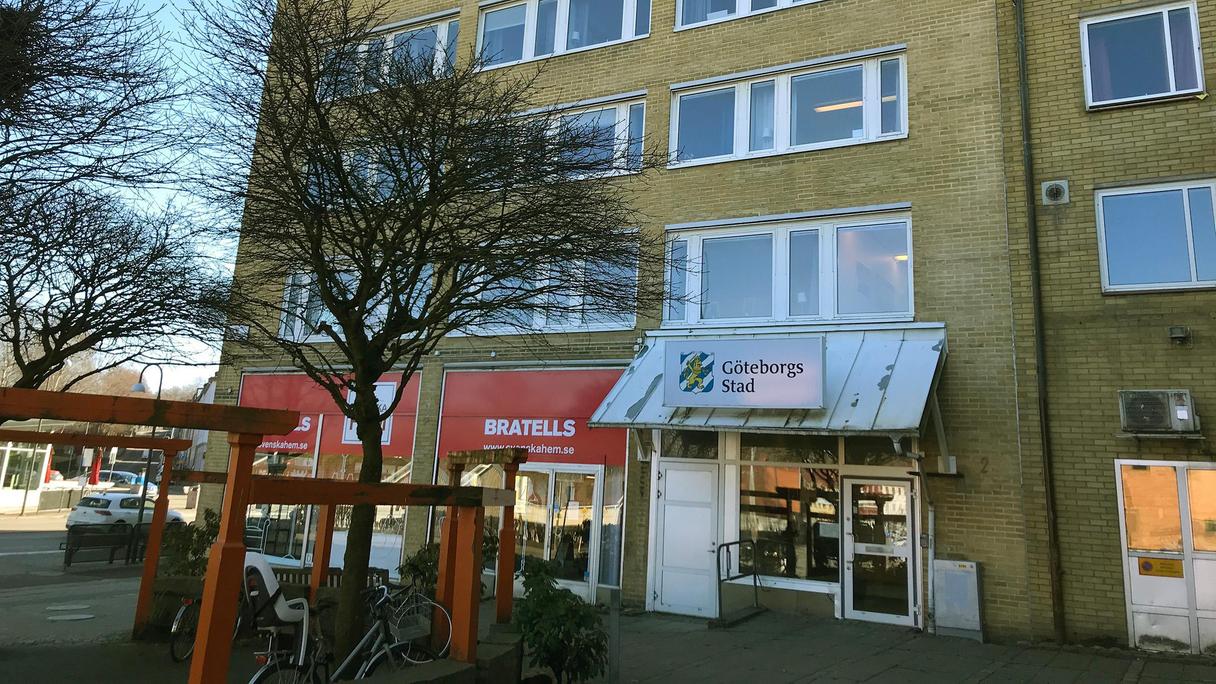 Entré med glasparti i ett gult tegelhus.