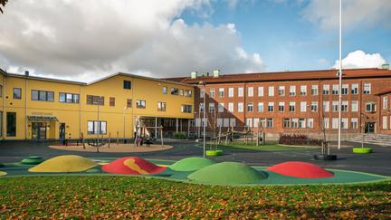 Gamlestadsskolans skolgård med skolbyggnaderna i bakgrunden.