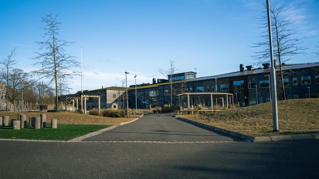 En överblick av Glöstorpsskolan med en lekplats i bakgrunden.