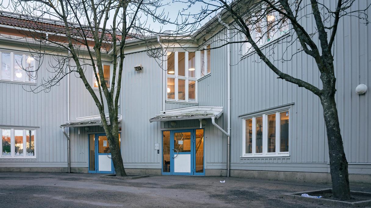 Entré till skola med ett par träd i bakgrunden.