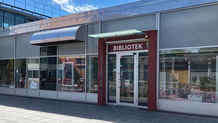 Fasad med fönster och glasdörr och skylten "Bibliotek"