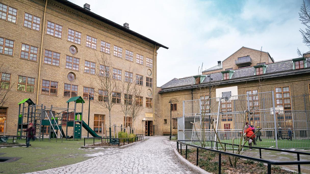 En översikt av Karl Johansskolan med en lekplats och några personer i bakgrunden. 