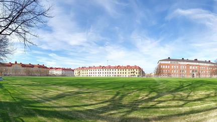 Konstgräsplan med hus i bakgrunden