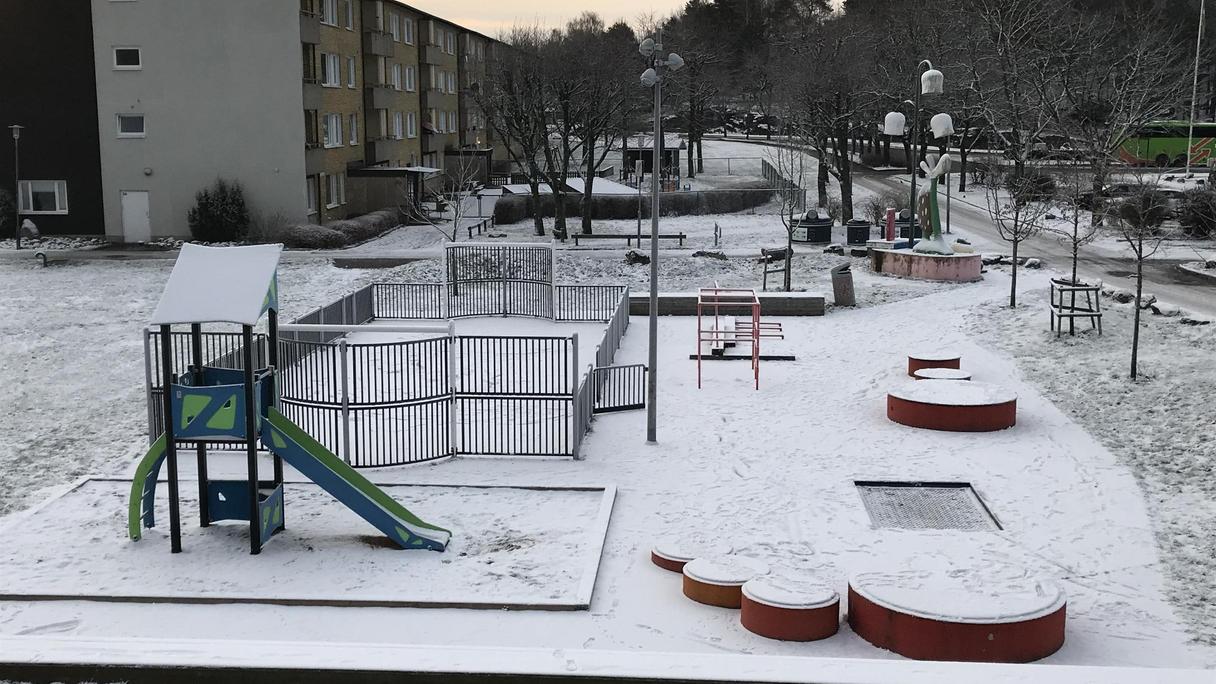 Snötäckt mark med bland annat en rutschkana och en studsmatta.